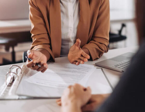the-iconic-image-refine-session-strategy-desk.jpg Woman in a camel blazer reviewing documents during a Refine Your I.C.O.N.I.C Self strategy session.